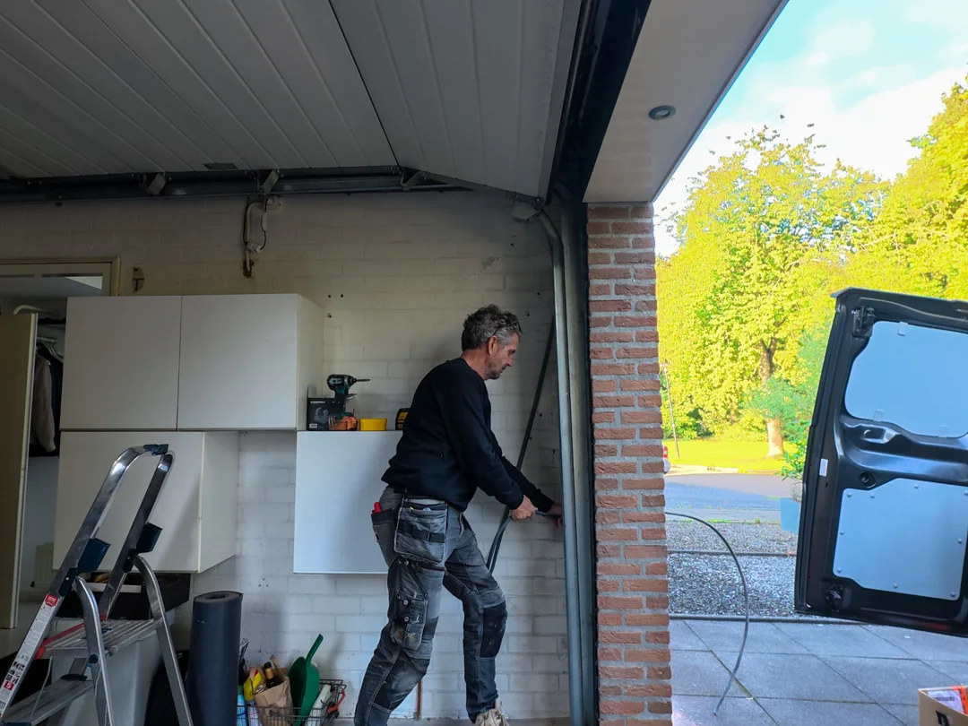 Monteur legt bekabeling aan in de garage