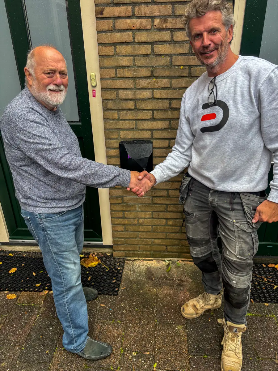 Klant en monteur van Donck Elektrotechniek geven elkaar een hand bij de nieuwe laadpaal in Maarssen