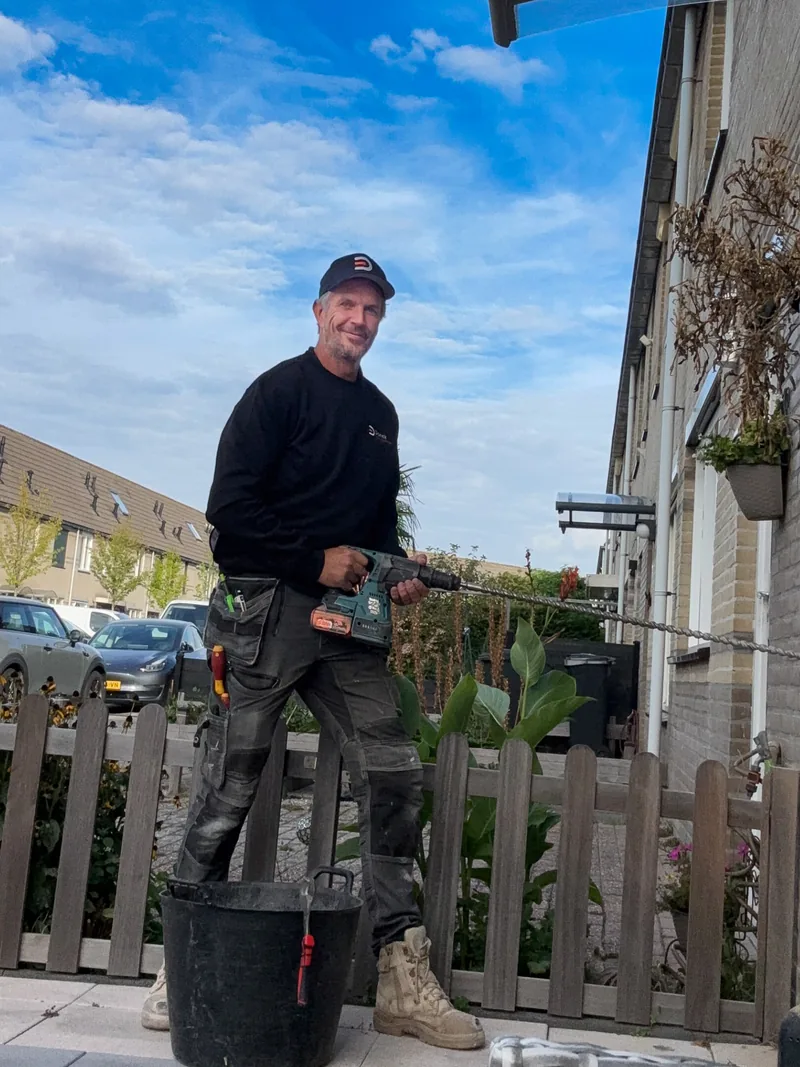 Martijn Verhulsdonck van Donck Elektrotechniek boort de gevel bij een laadpaalinstallatie in De Ronde Venen