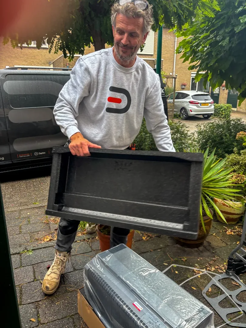 Monteur verwijdert het beschermende verpakkingsmateriaal van de thuisbatterij
