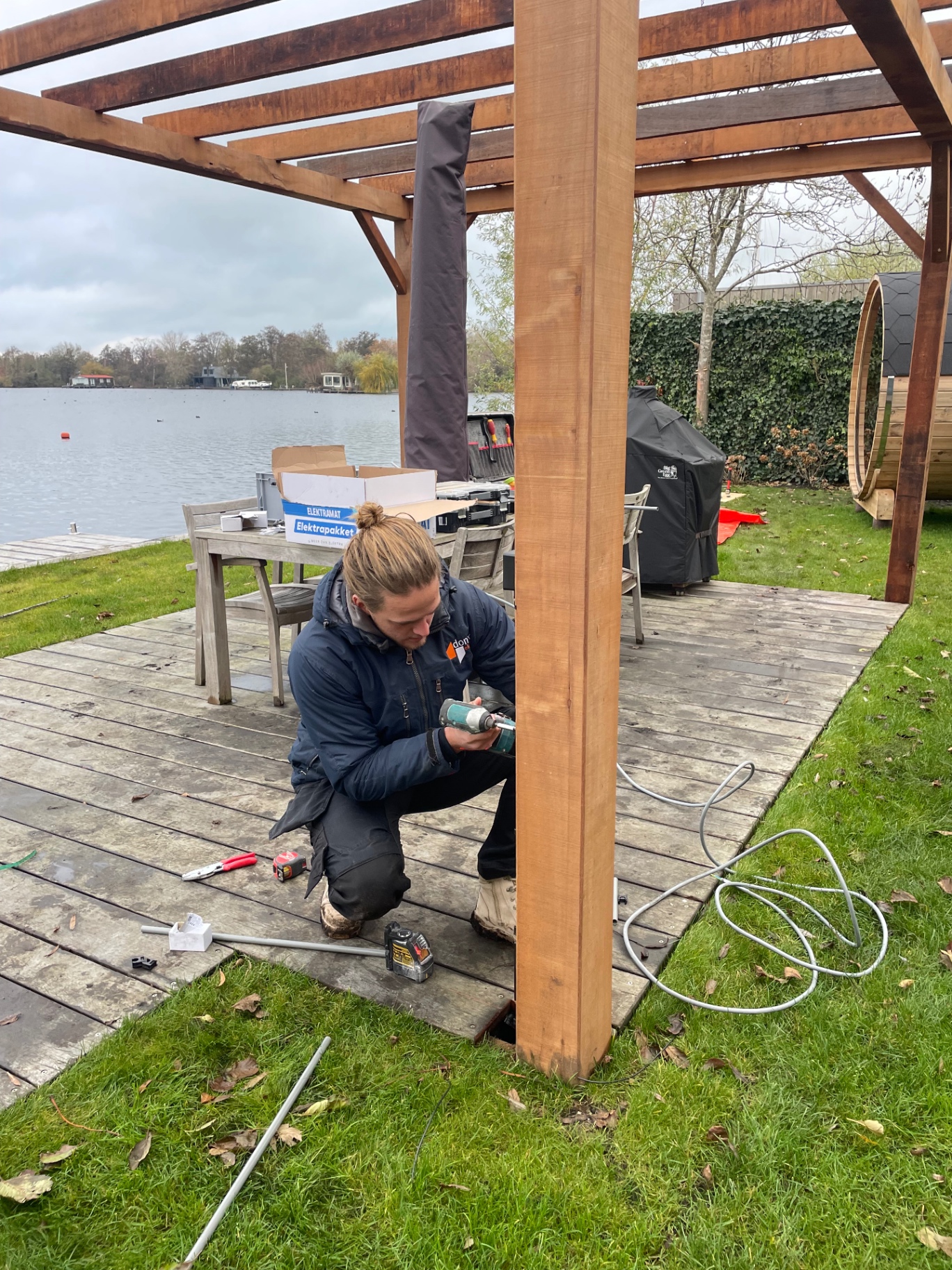 Monteur installeert buitenverlichting bij pergola in Vinkeveen