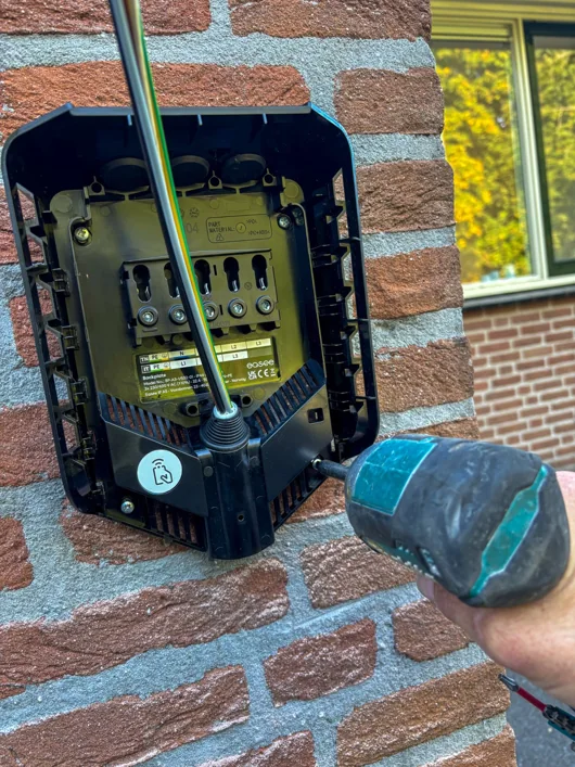Montage van de Easee-laadpaal aan de bakstenen wand